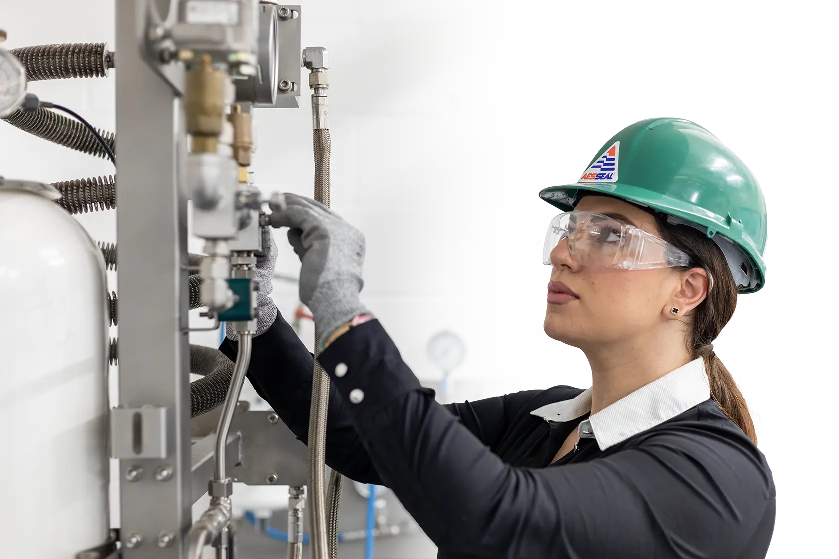A female engineer in PPE inspects a gas panel.